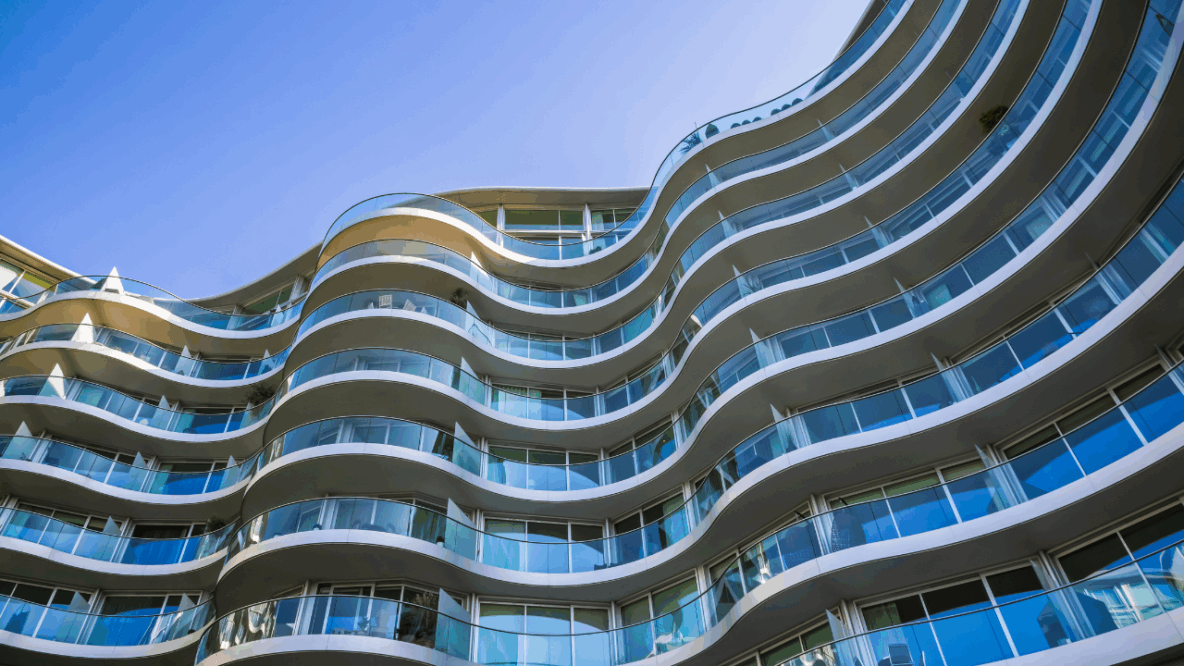Tall glass building with blue sky in background